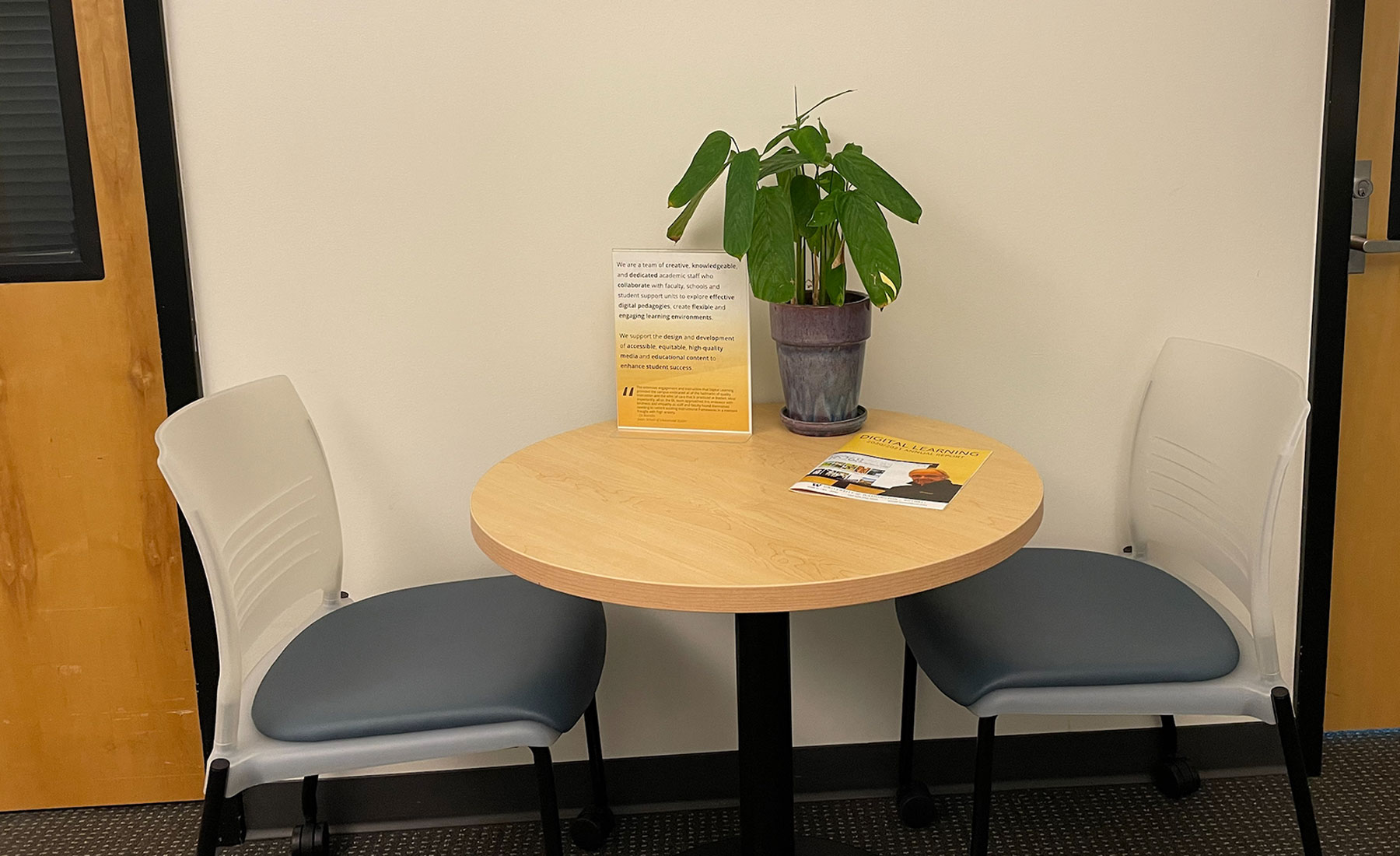 Small round table with two chairs tucked underneath it. 