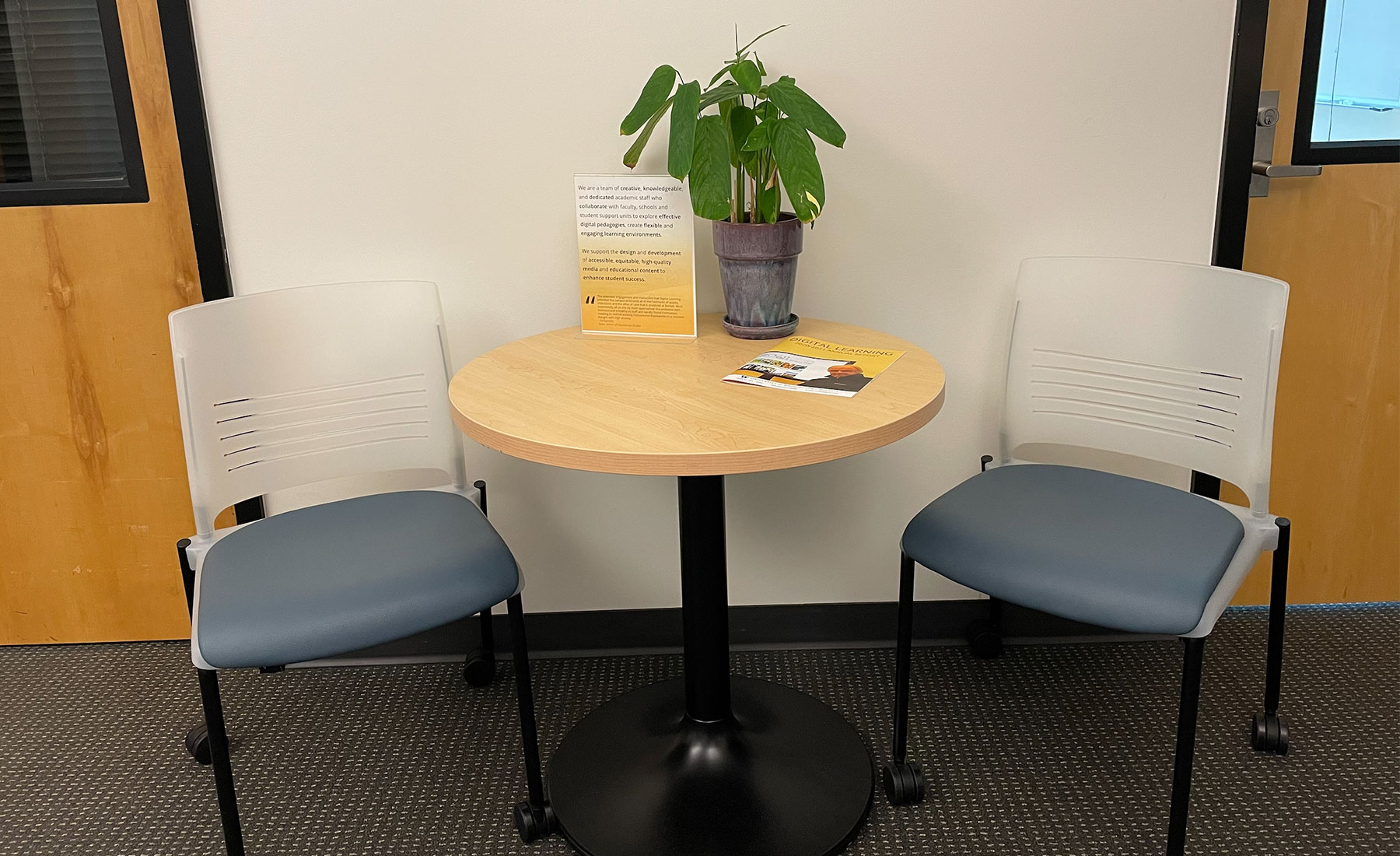 Small round table with two chairs opened at an angle for easy for sitting. 