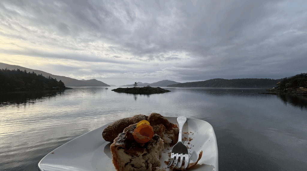 View of islands of the Puget Sound with a slice of quiche on the plate in the forground.