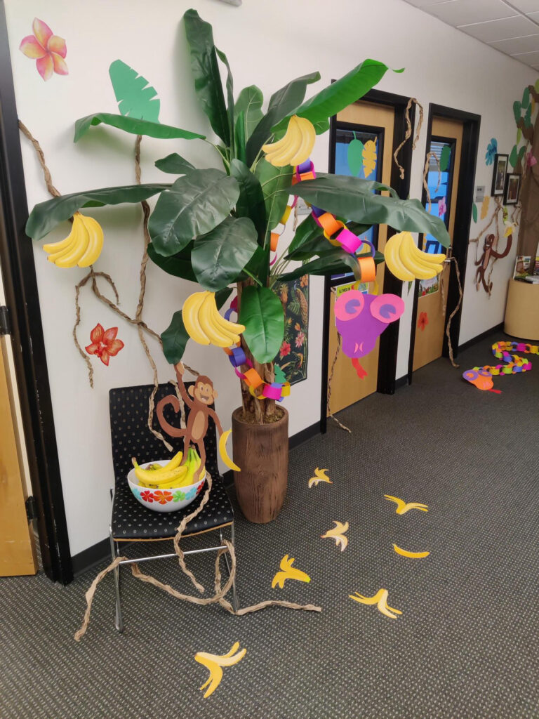 Office space decorated with many jungle themed items including signs, photos, and vines.